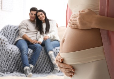 Image of Surrogate mother and intended parents in room