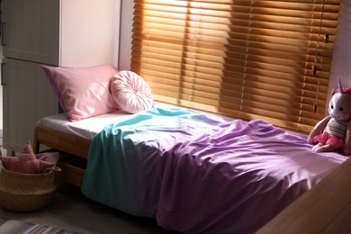 Bed with stylish linens in children's room