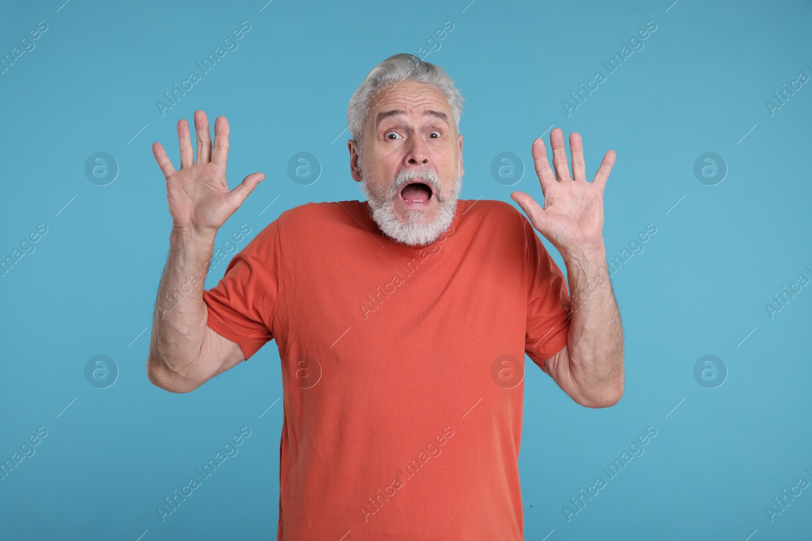 Photo of Portrait of surprised senior man on light blue background