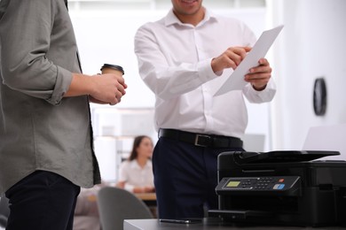 Employees near modern printer in office, closeup