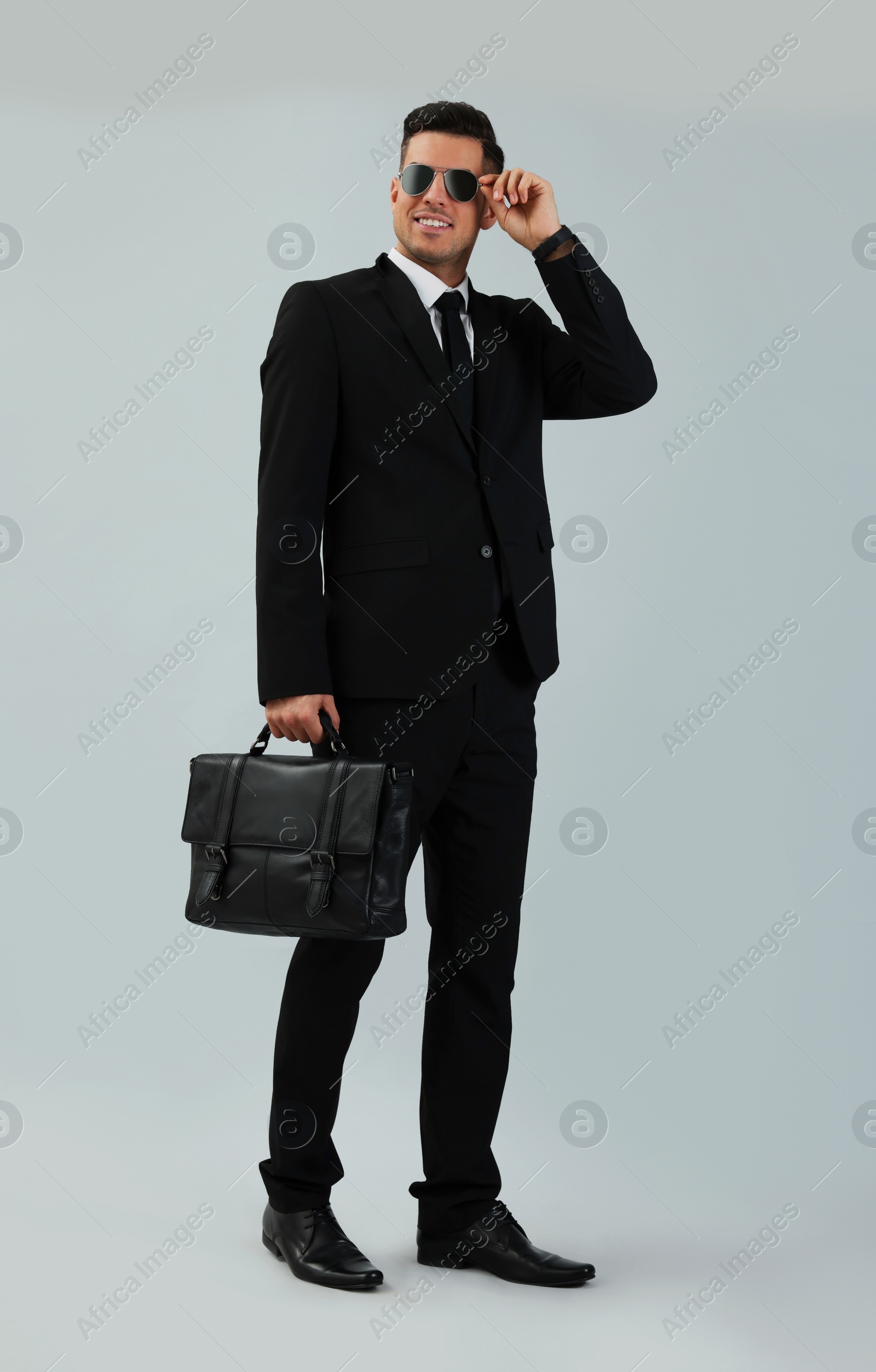 Photo of Businessman with stylish leather briefcase on light background