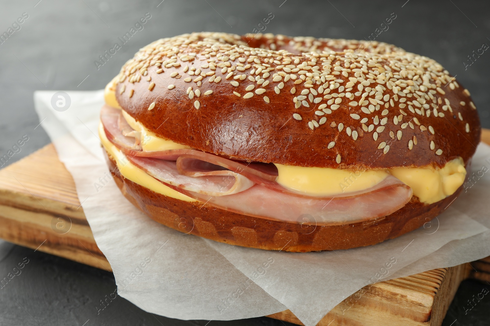 Delicious bagel with ham and cheese on grey table, closeup Photo of Delicious bagel with ham and cheese on grey table, closeup