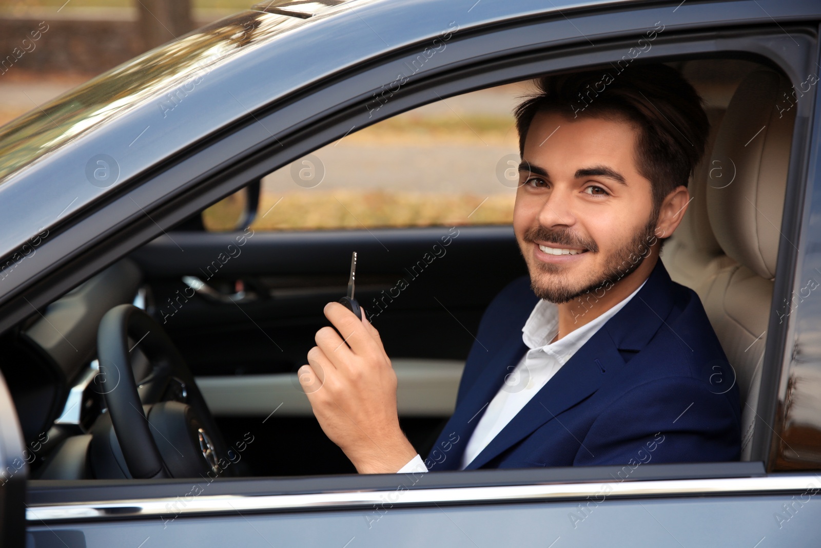 Photo of Young man holding car key in auto. Driving license test