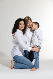 Little children with their mother on white background