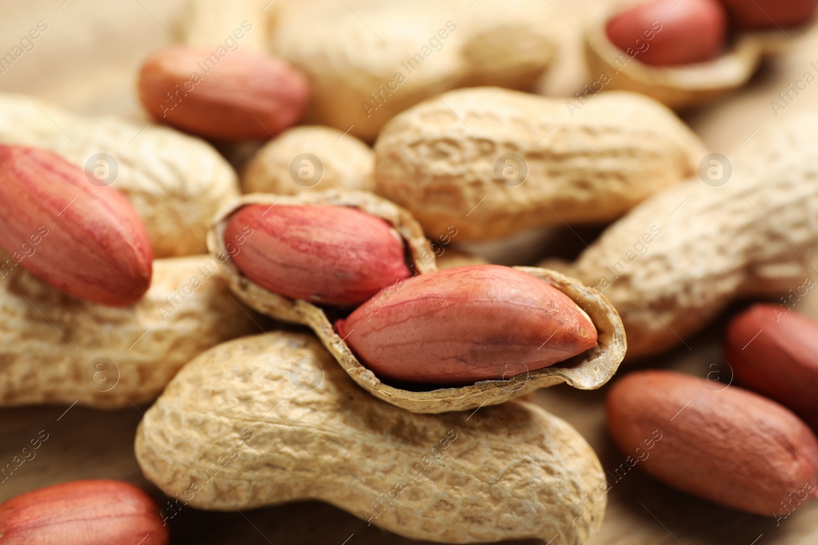 Photo of Fresh unpeeled peanuts on table, closeup view