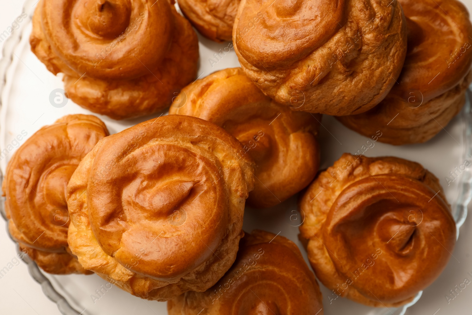 Photo of Delicious profiteroles on white table, top view