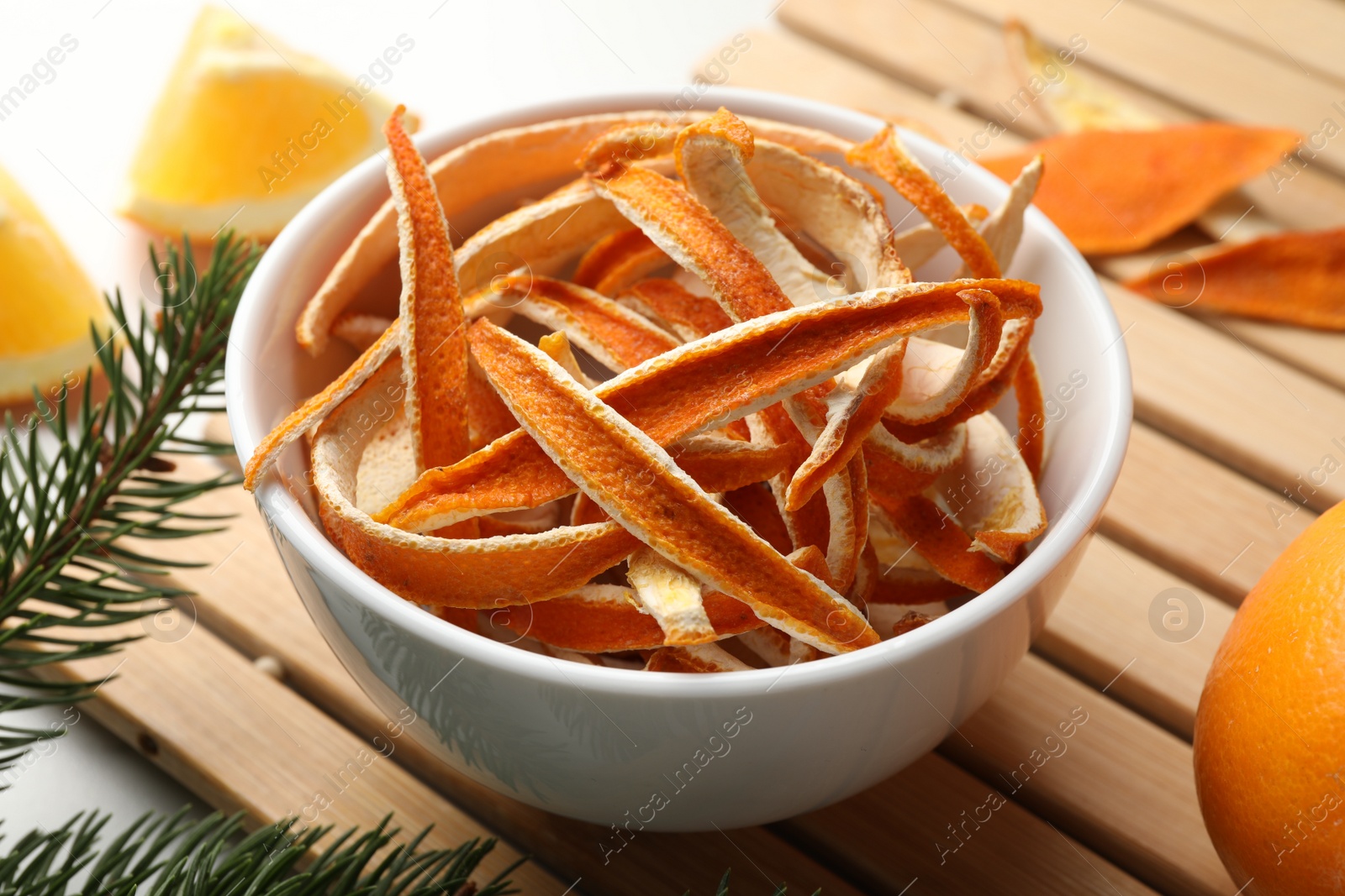 Photo of Dry peels, oranges and fir branch on white table, closeup