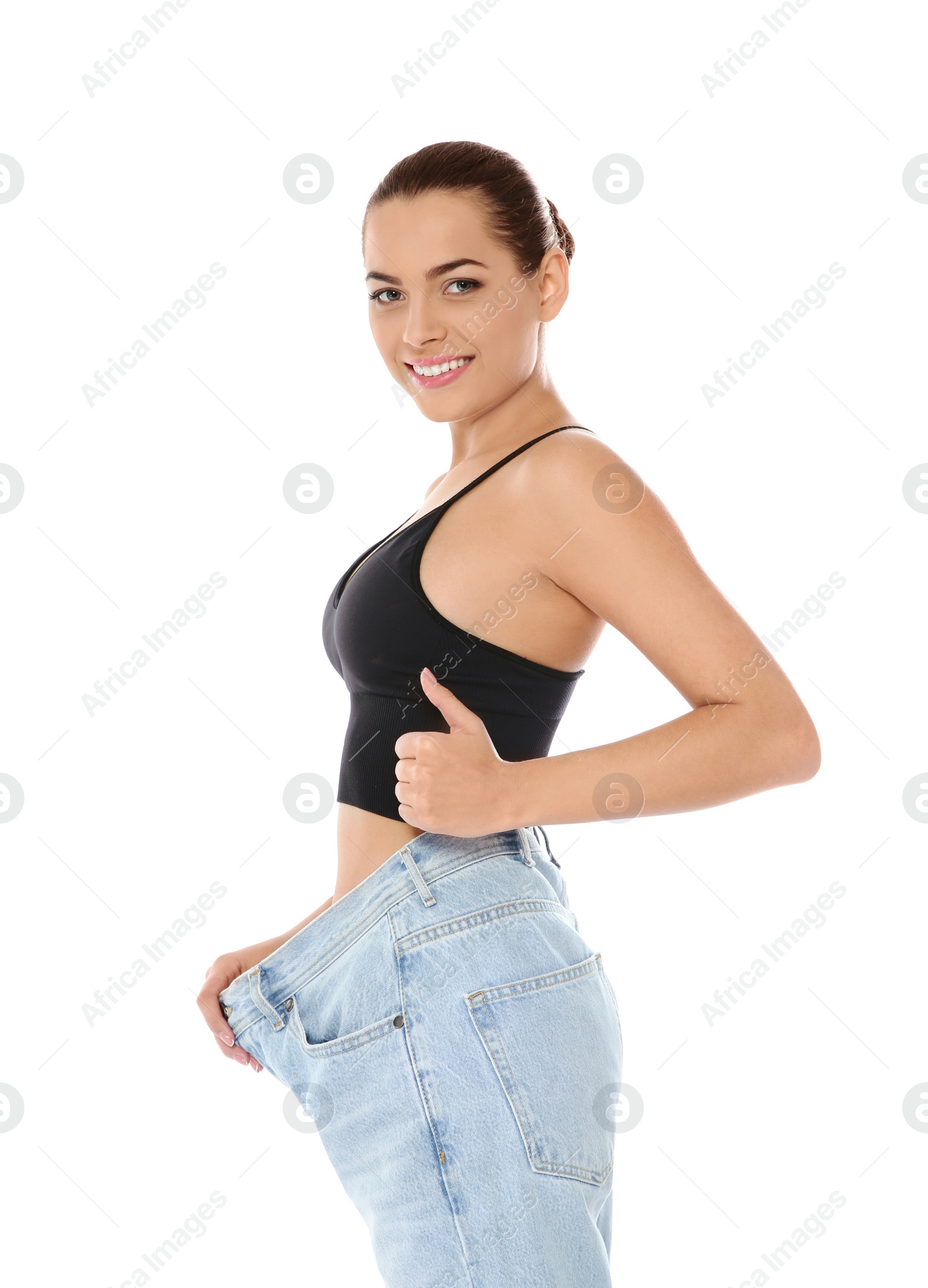 Photo of Slim woman in oversized jeans on white background. Weight loss