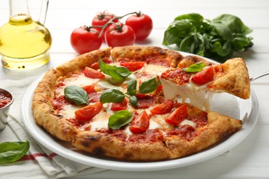 Photo of Taking piece of delicious Margherita pizza at white table, closeup