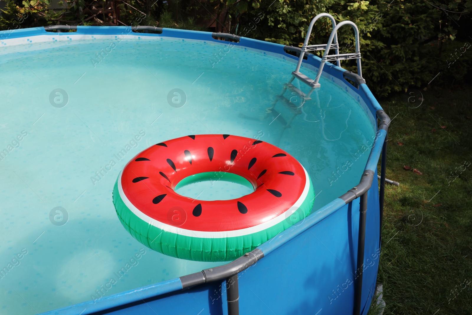 Photo of Inflatable ring floating on water in above ground swimming pool outdoors