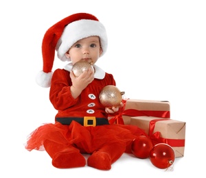 Photo of Festively dressed baby with gift boxes on white background. Christmas celebration