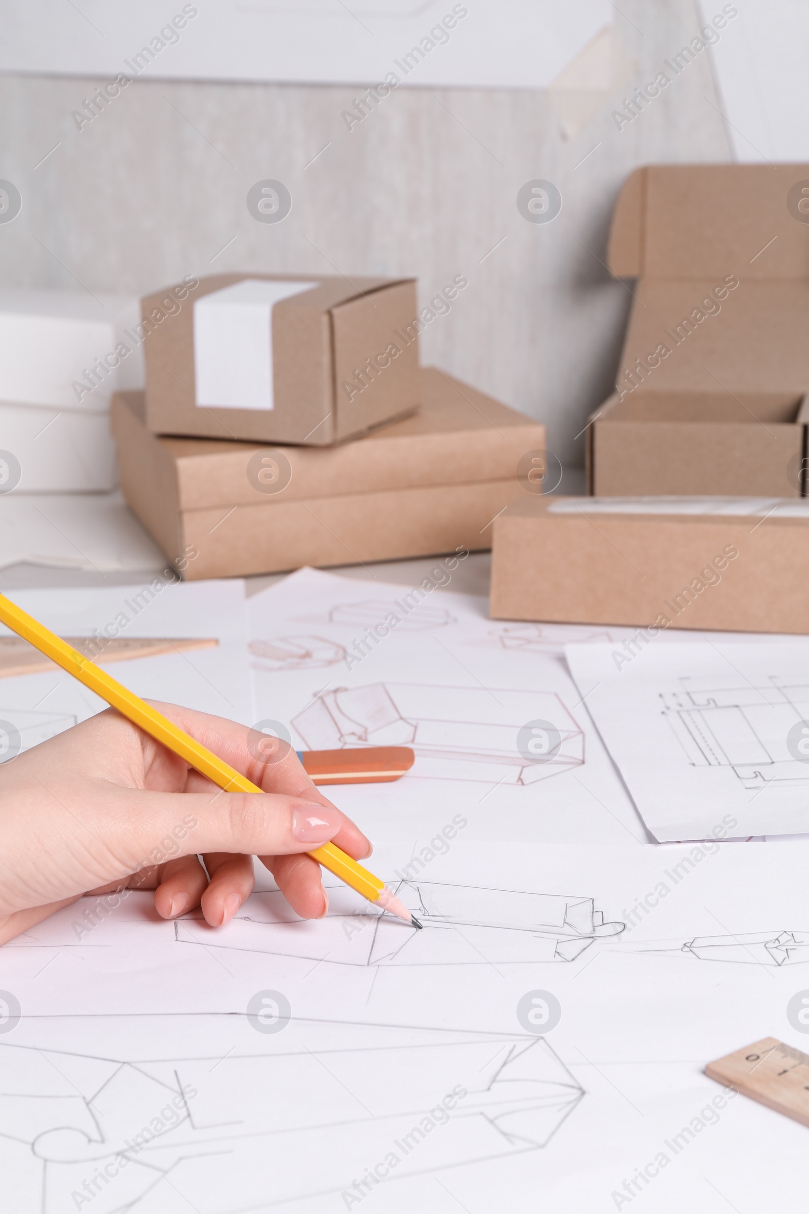 Photo of Woman creating packaging design at table, closeup