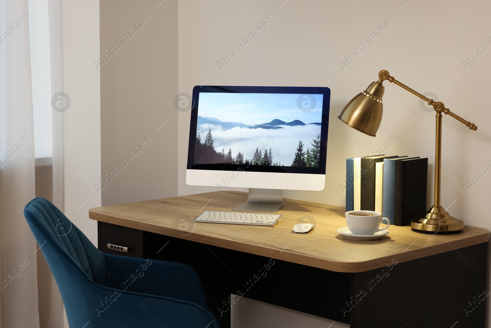 Photo of Cozy workspace with computer on wooden desk and comfortable chair at home