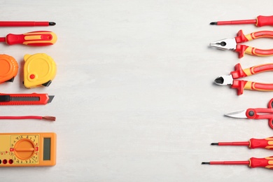 Photo of Flat lay composition with electrician's tools and space for text on light background