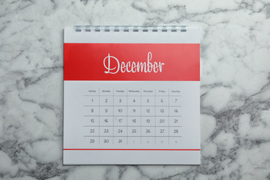 Photo of December calendar on marble background, top view