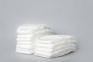 Photo of Stacks of diapers on light grey background