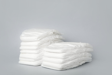 Stacks of diapers on light grey background