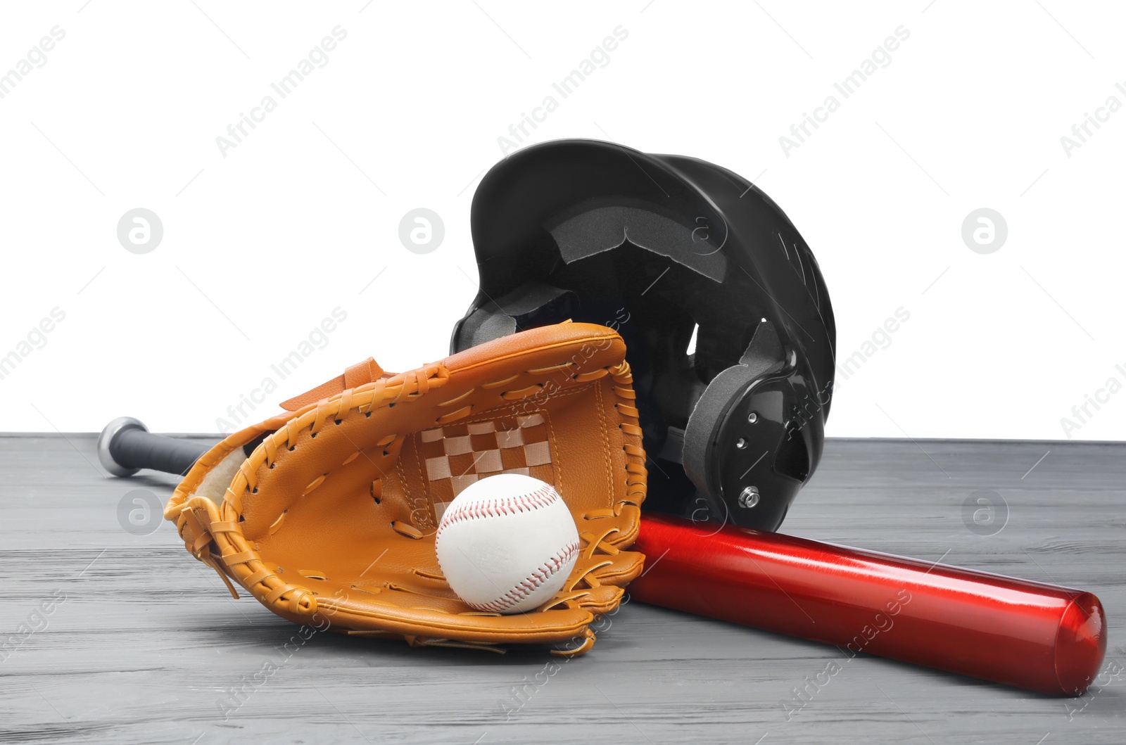 Photo of Baseball glove, bat, ball and batting helmet on grey wooden table against white background