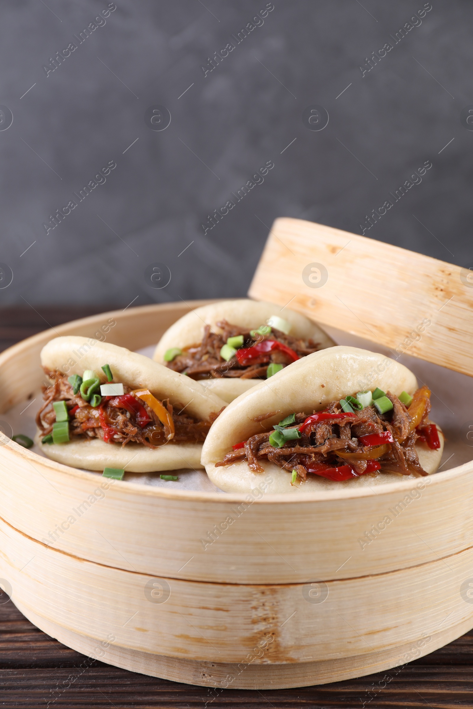 Photo of Delicious gua bao (pork belly buns) on wooden table, closeup