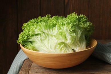 Photo of Fresh lettuce on wooden table. Salad greens