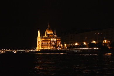 BUDAPEST, HUNGARY - APRIL 27, 2019: Beautiful night cityscape with illuminated Parliament Building and Margaret Bridge across Danube river