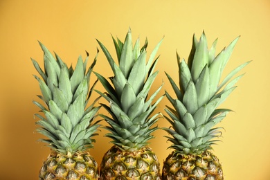 Photo of Fresh ripe juicy pineapples on yellow background