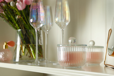 Photo of White shelving unit with glassware and different decorative elements