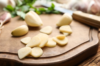 Photo of Fresh whole and cut garlic on wooden table, closeup. Organic product