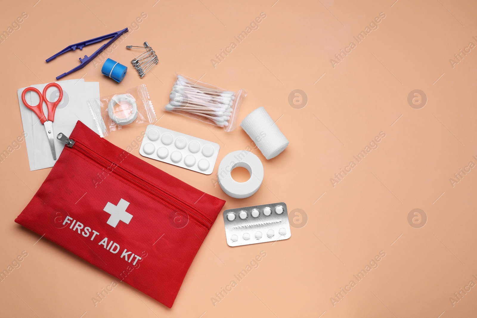 Photo of Flat lay composition with first aid kit on pale coral background. Space for text