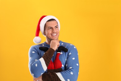 Photo of Handsome man wearing Santa hat on yellow background