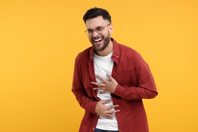 Photo of Handsome young man laughing on yellow background