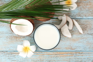 Photo of Glass of coconut milk on wooden table, top view