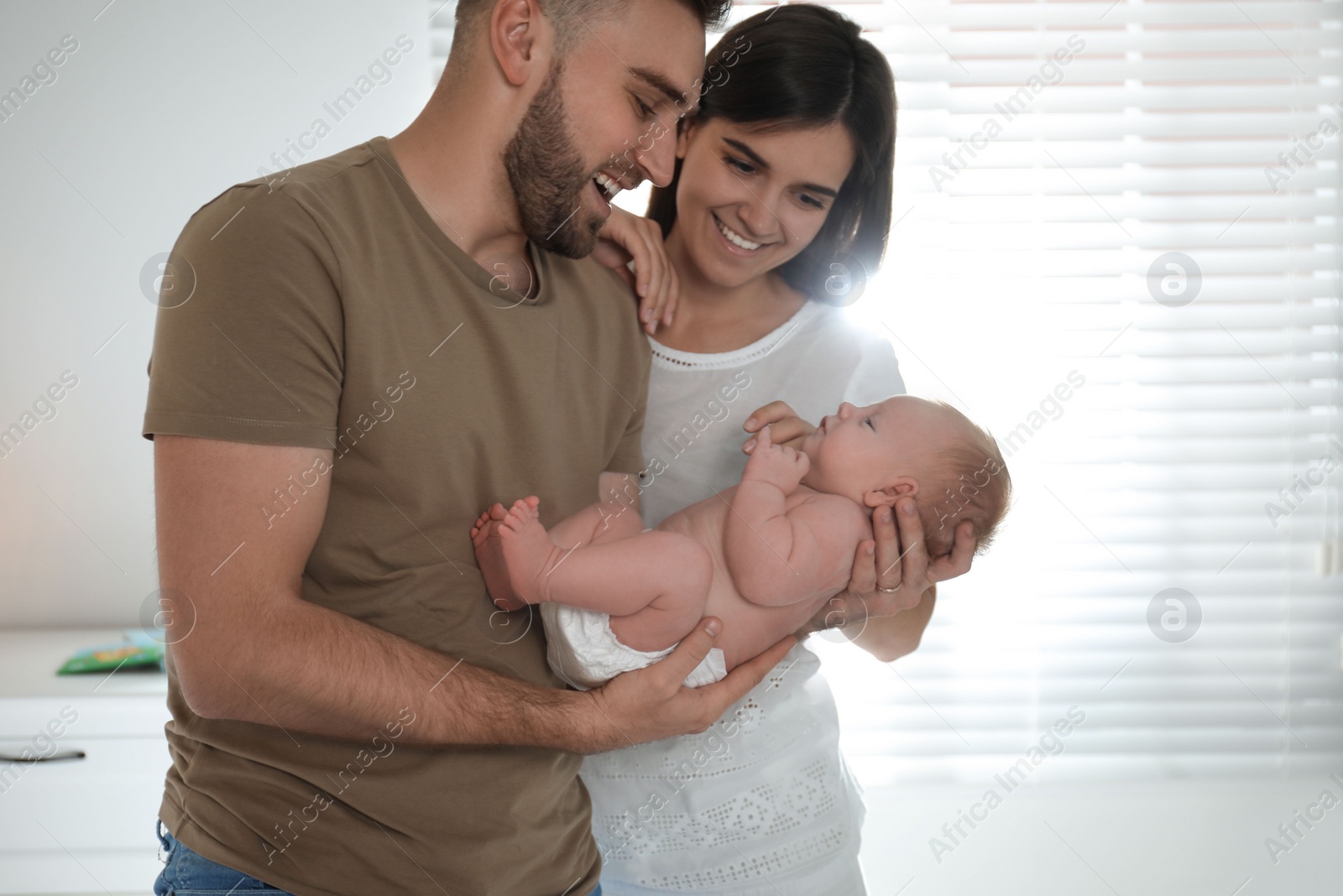 Photo of Happy couple with their newborn baby at home