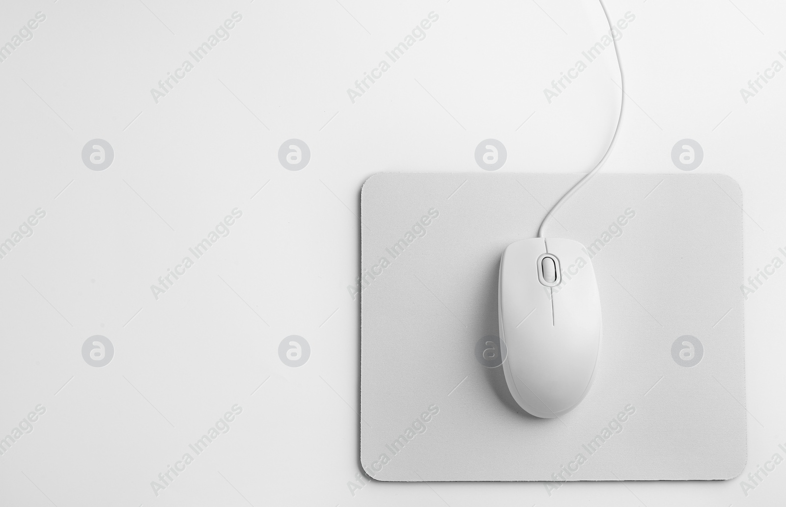 Photo of Modern wired optical mouse and pad on white background, top view
