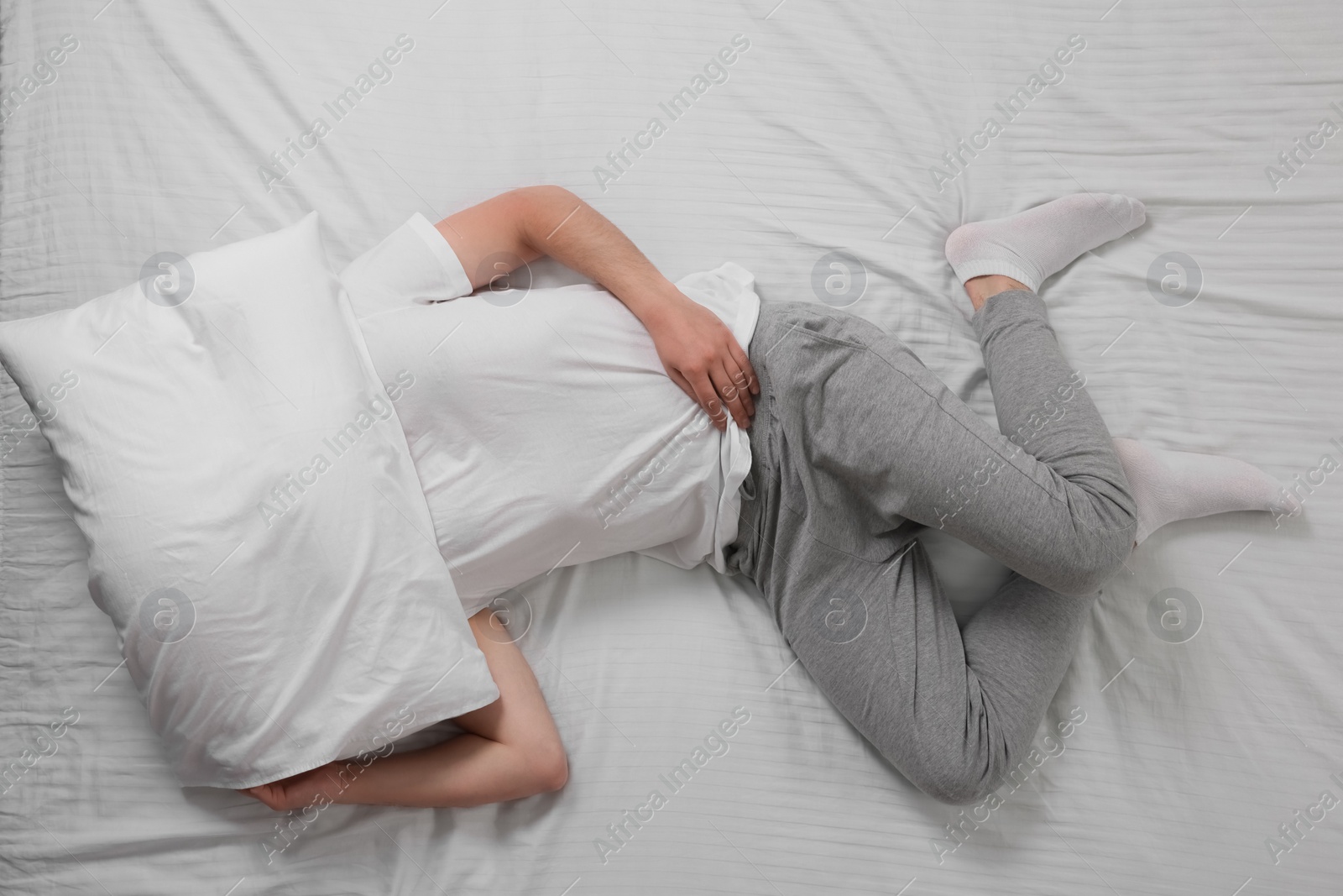 Photo of Man suffering from insomnia in bed, top view