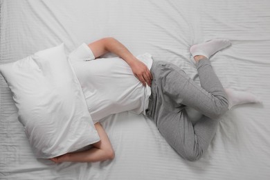 Man suffering from insomnia in bed, top view