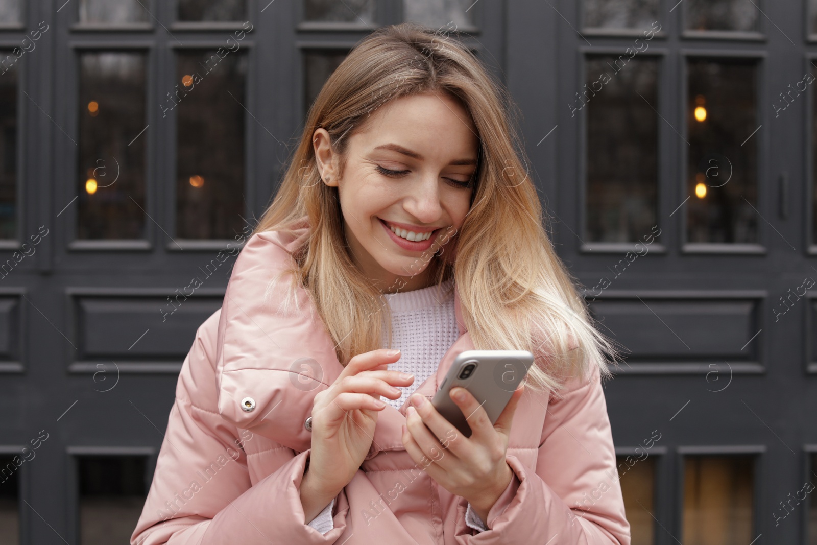 Photo of Beautiful young woman using mobile phone outdoors