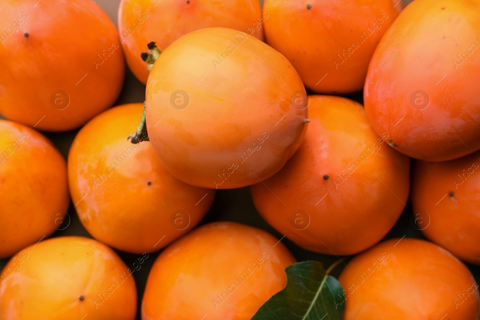 Photo of Delicious ripe juicy persimmons as background, top view
