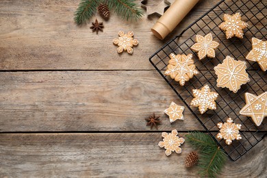 Photo of Tasty Christmas cookies and fir branches on wooden table, flat lay. Space for text