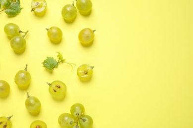 Photo of Flat lay composition with fresh ripe juicy grapes on yellow background, space for text