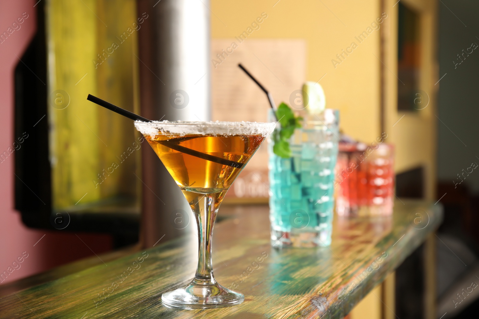 Photo of Glasses with delicious cocktails on counter in bar