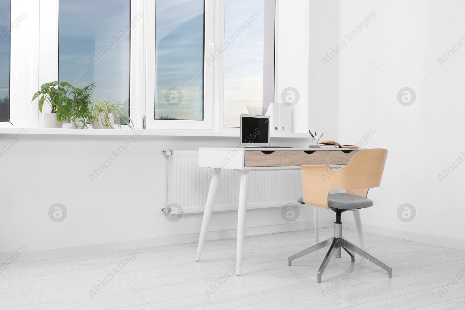 Photo of Comfortable workplace near window in stylish room. Home office