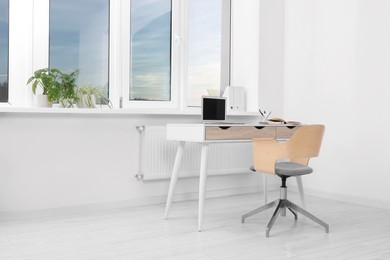 Comfortable workplace near window in stylish room. Home office