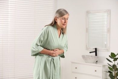 Photo of Menopause. Woman suffering from digestive problems in bathroom