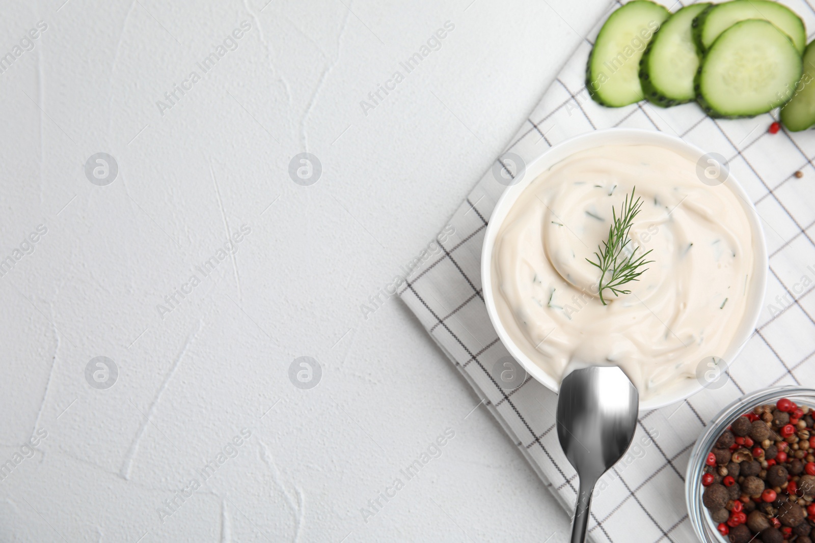 Photo of Tasty creamy dill sauce and ingredients on white table, flat lay. Space for text