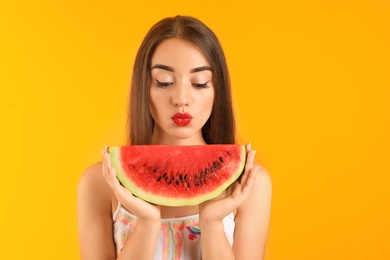 Photo of Beautiful young woman posing with watermelon on color background