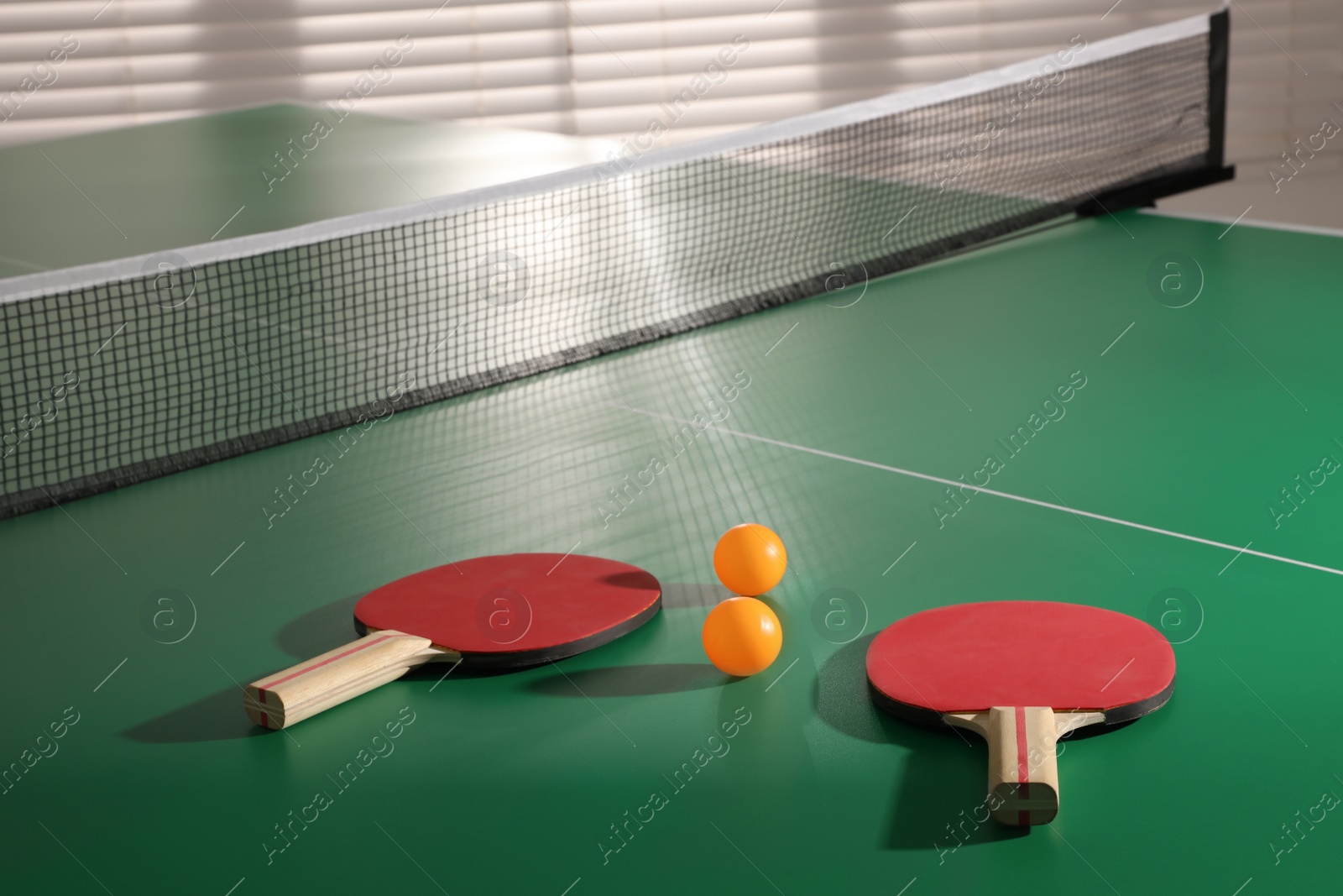 Photo of Rackets and balls on ping pong table indoors