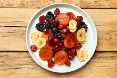 Mix of delicious dried fruits on wooden table, top view