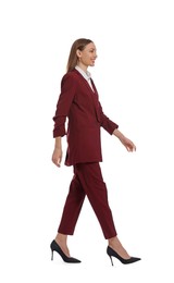 Photo of Young woman in burgundy suit walking on white background