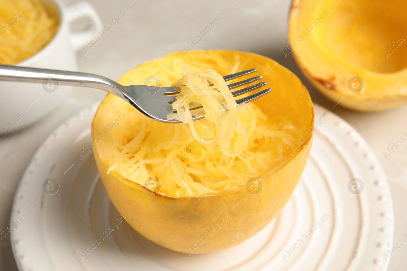 Photo of Fork with flesh over cooked spaghetti squash on plate